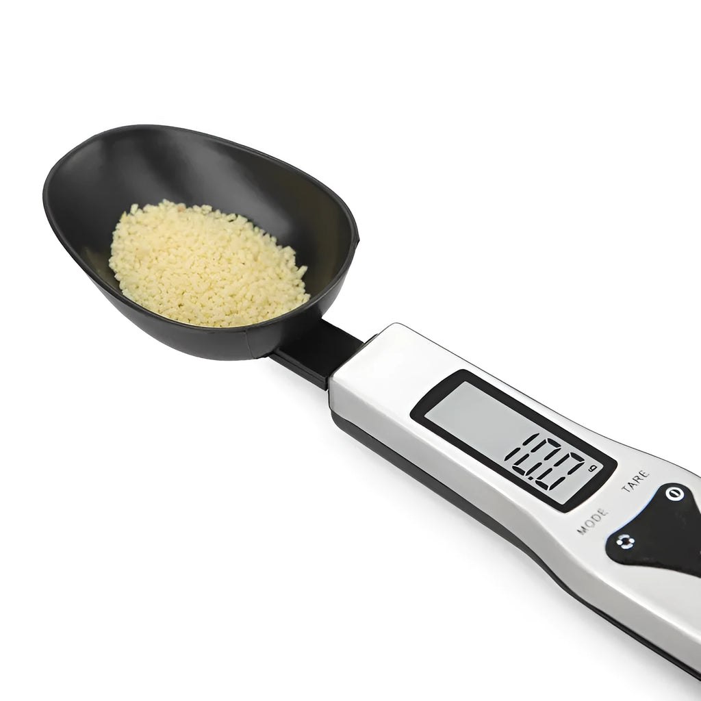Smart digital measuring spoon with integrated display showing weight, next to AAA batteries.