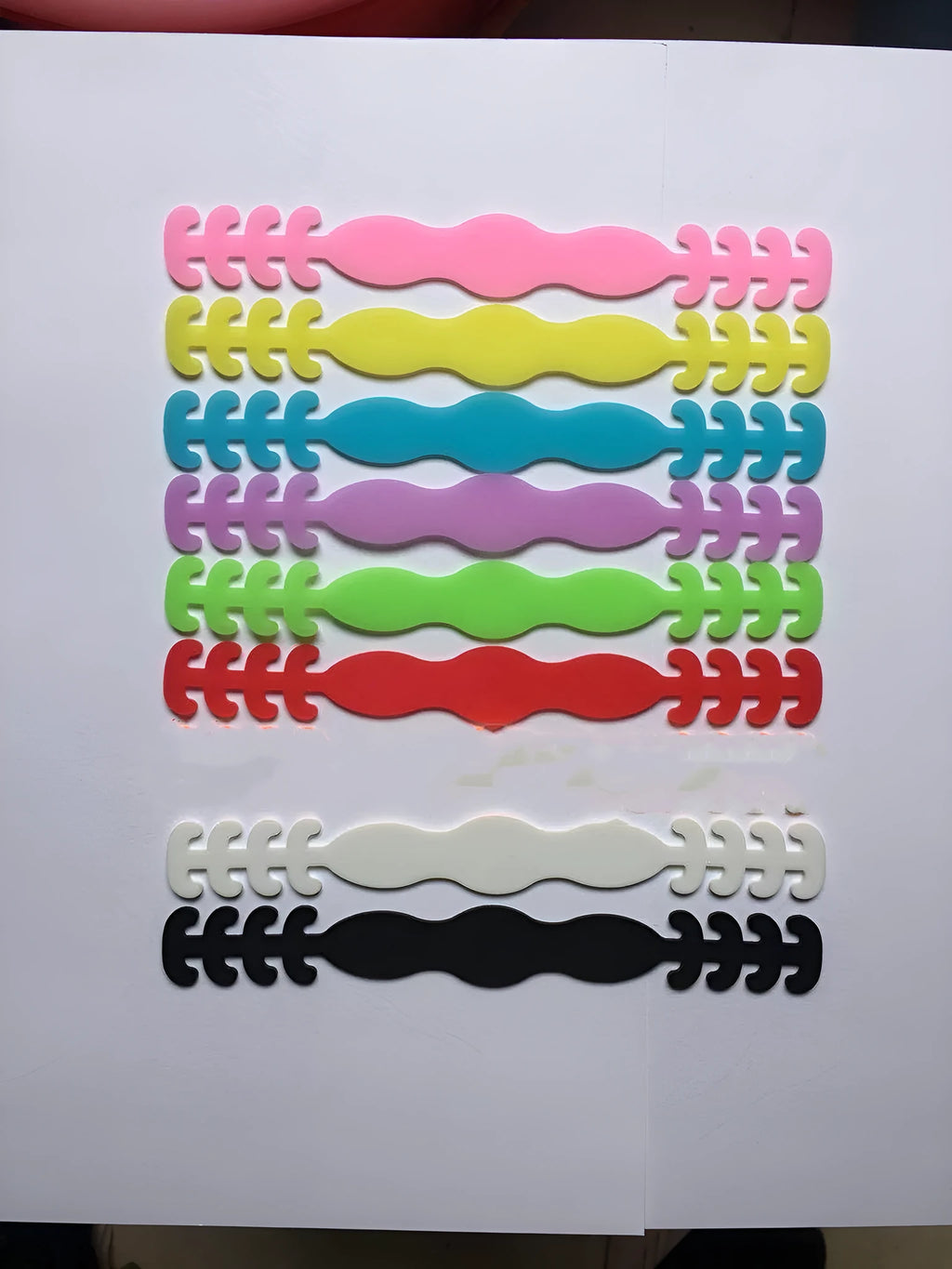 Eight silicone protective buckles in different colours for cable organisation