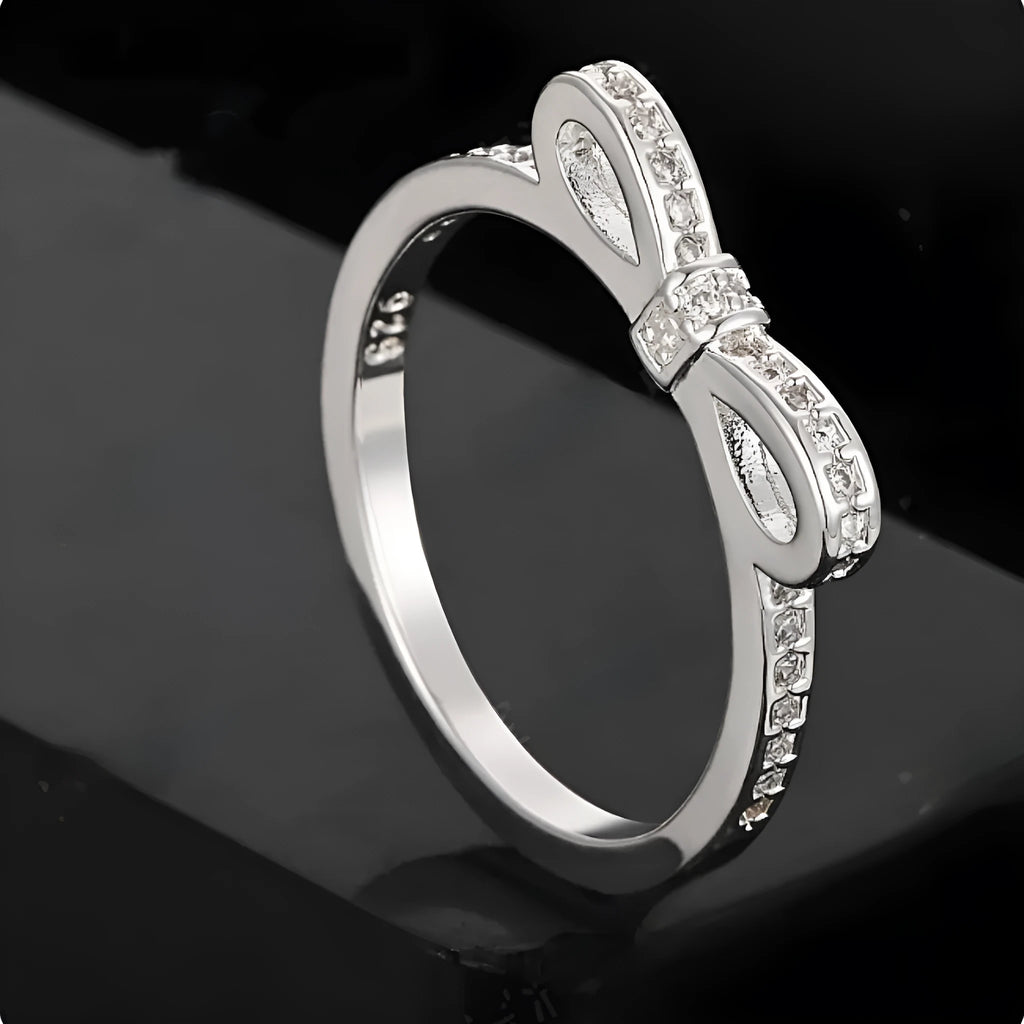 Silver-coloured fashion ring with a bow design adorned with clear zircon crystal stones.
