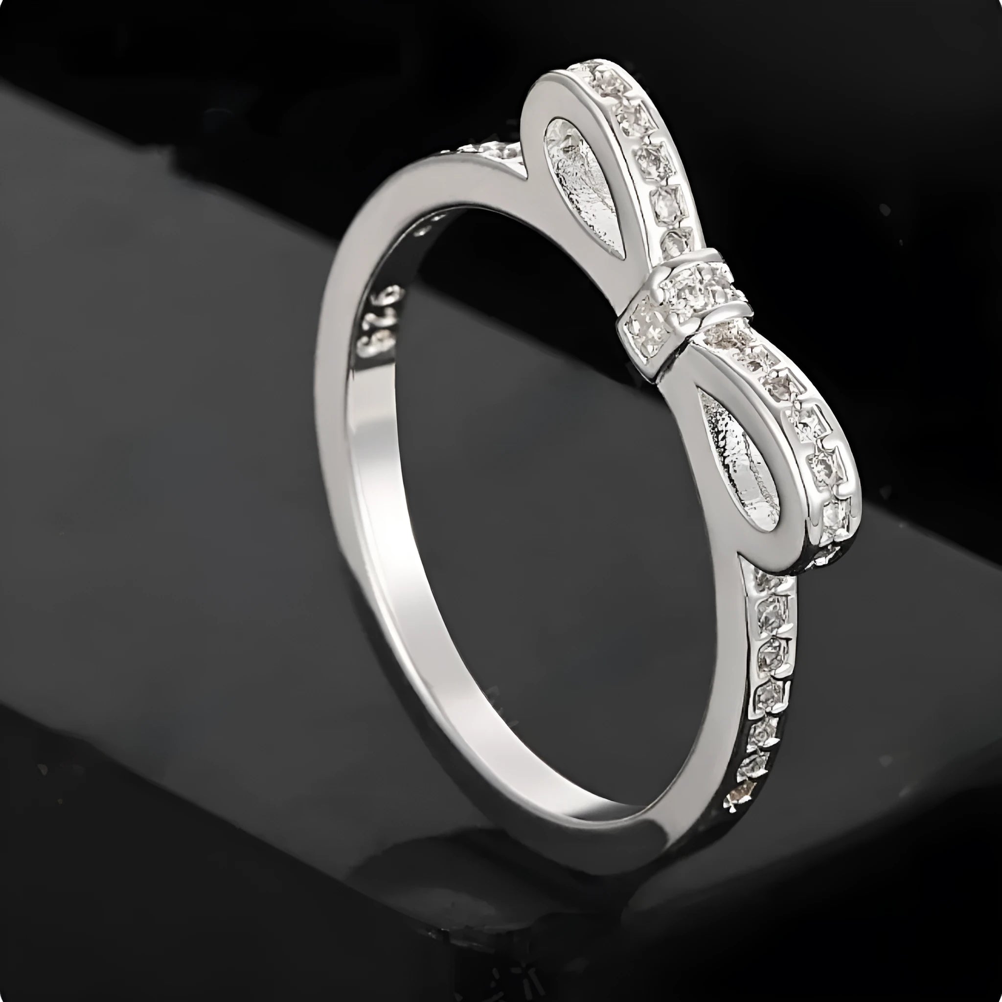Silver-coloured fashion ring with a bow design adorned with clear zircon crystal stones.