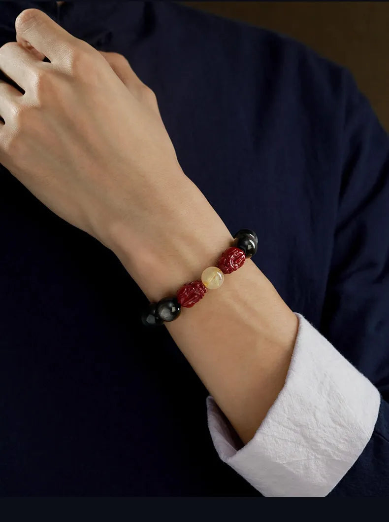 Natural cinnabar bead bracelet with a carved gold or silver animal charm in a gift box.
