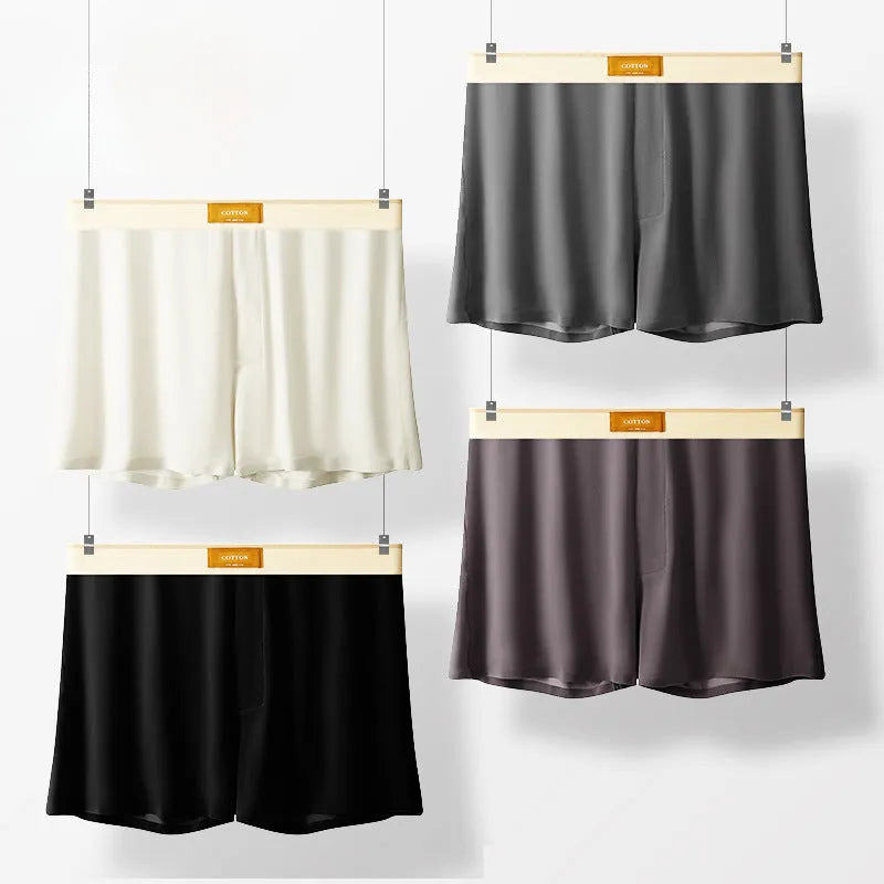 Pack of three men's loose fit ice silk boxer shorts in solid colours on a mid-waist model.