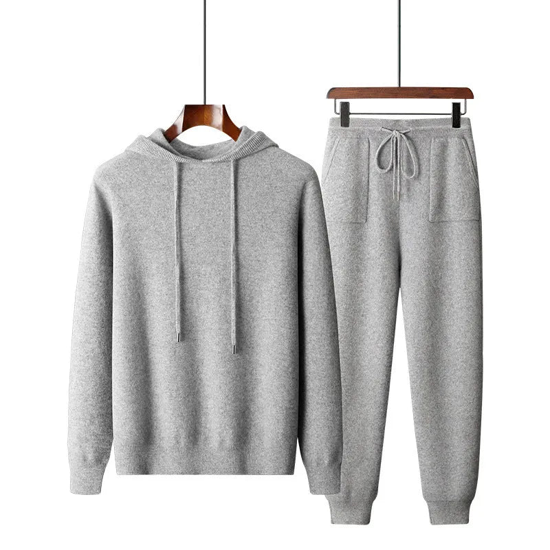 Man wearing a light grey cashmere hooded sweatshirt and matching trousers, a casual winter two-piece set.