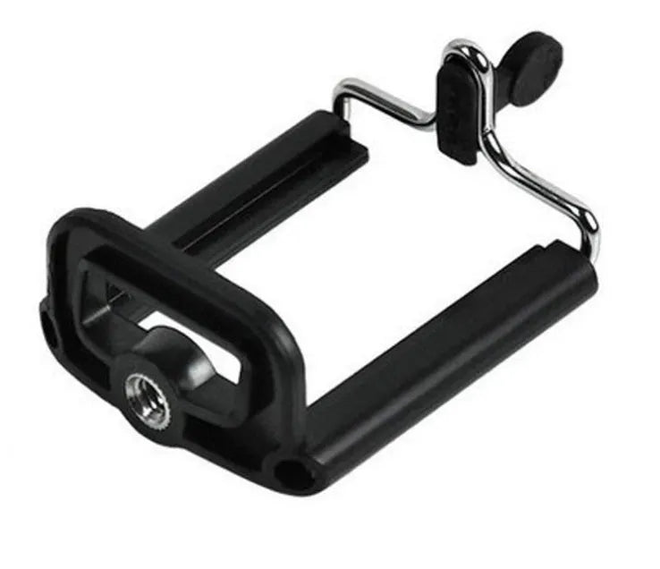 Black mini flexible tripod extended on a table with a silver U-shaped phone clip attached.