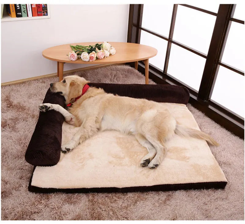 A corduroy pet sofa dog bed with bolsters, shown in a grey colour, placed on a hardwood floor.