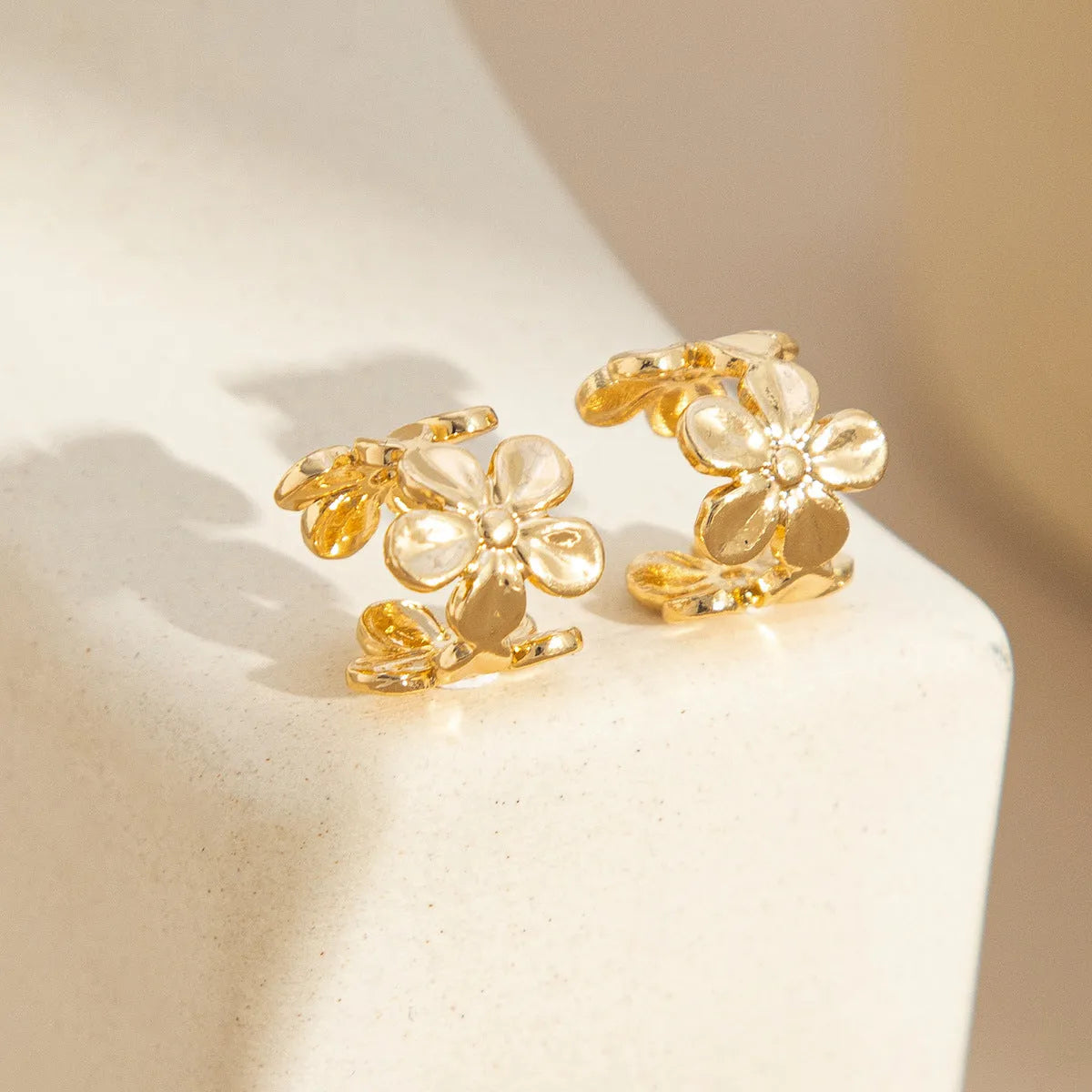 Gold electroplated alloy earrings with starfish and conch designs for women.