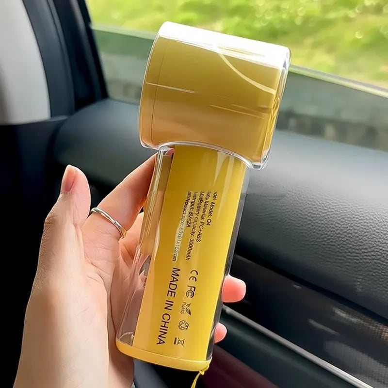 Small yellow handheld fan with refrigeration ice compress function on a table