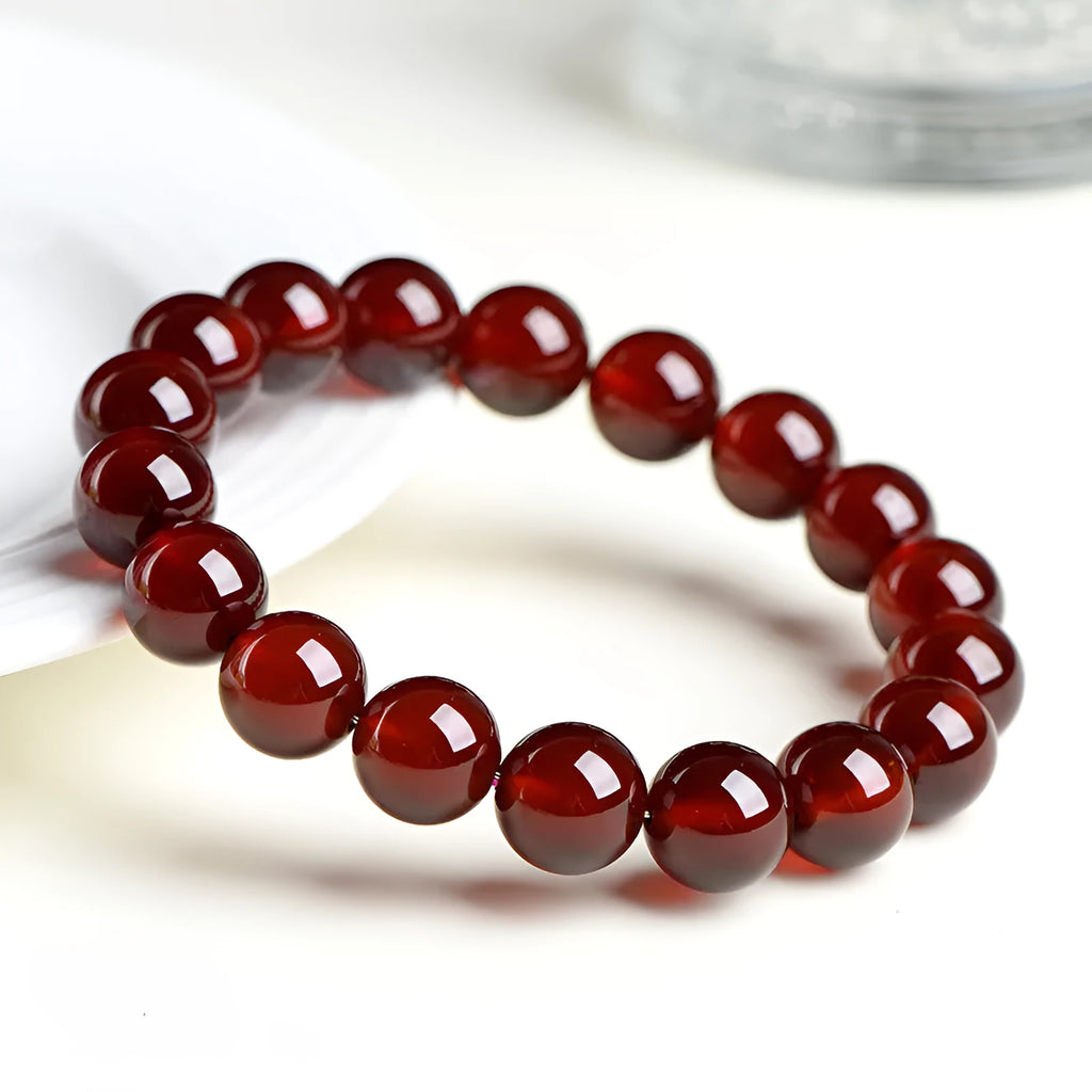 Orange red garnet crystal ball bracelet with retro ruyi design on a wrist