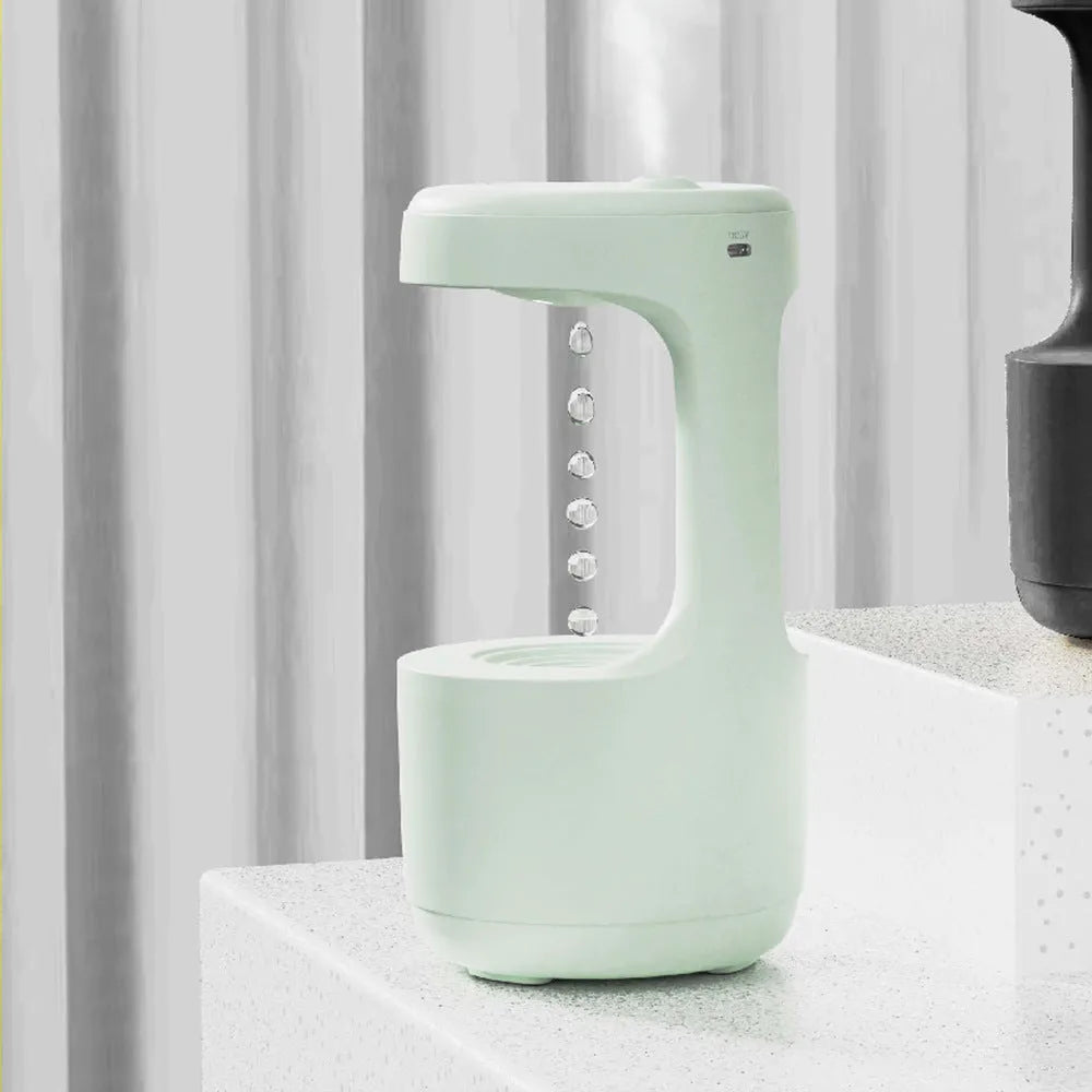 White columnar anti-gravity humidifier with LED clock display emitting mist on a wooden desk.