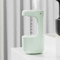 White columnar anti-gravity humidifier with LED clock display emitting mist on a wooden desk.