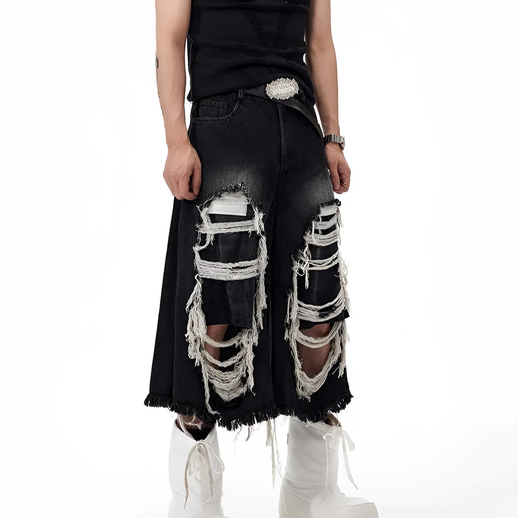 Woman wearing black distressed wide leg cropped jeans with ripped patches.