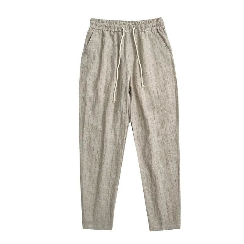 Man wearing beige striped cropped casual cotton-linen trousers on a summer day.