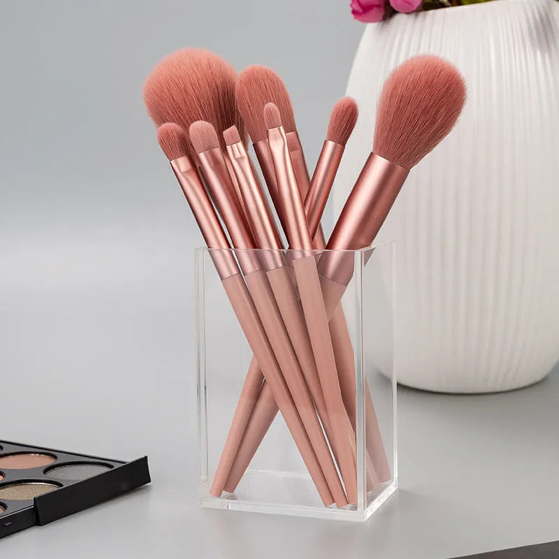 8-piece pink makeup brush set with man-made fibre bristles and plastic handles on white background