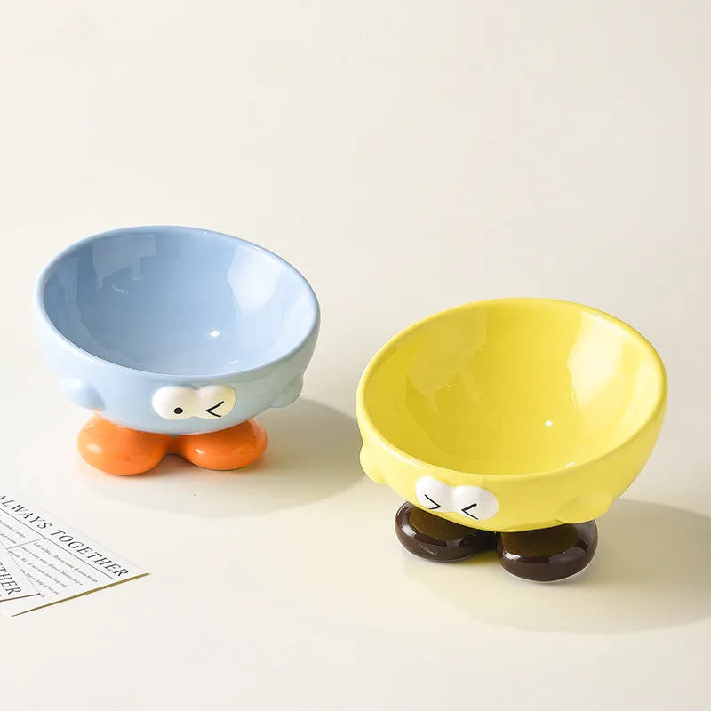 Blue ceramic oblique pet bowl with tall sides and a cute expression print for cervical spine support.