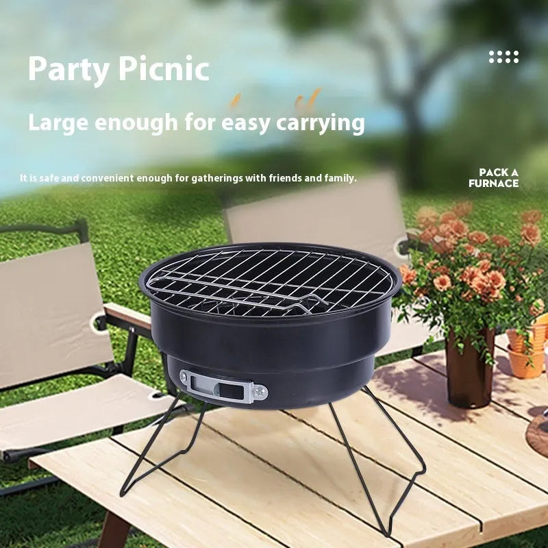 Small, round, folding metal ice stove grill with mesh top and legs, set up for outdoor use.
