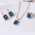 Crystal bridal three piece jewellery set with alloy setting, artificial gems, adjustable chain necklace, earrings, and ring on white background