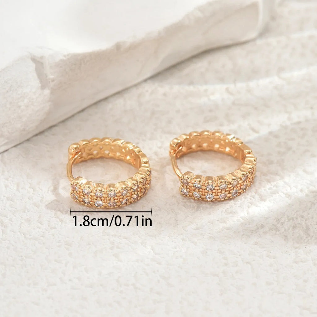 A pair of copper geometry pattern ear studs with round, dot, and ring design elements.