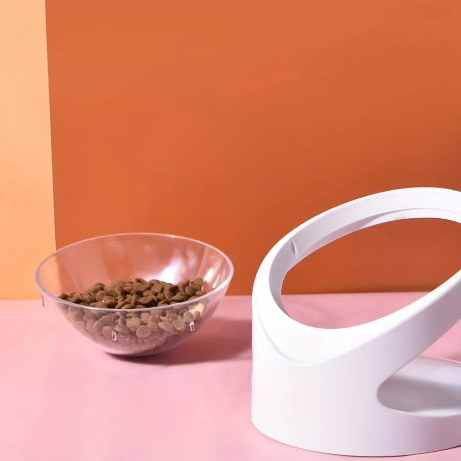 White elevated cat food bowl with a tilted surface on a raised platform.