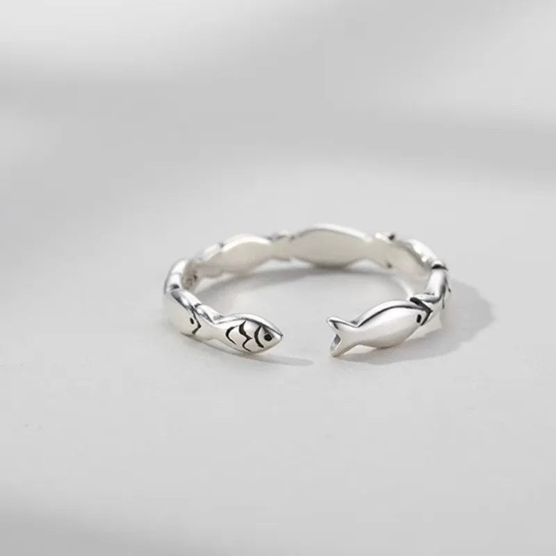 Women's sterling silver adjustable fish ring with carp motif on finger.