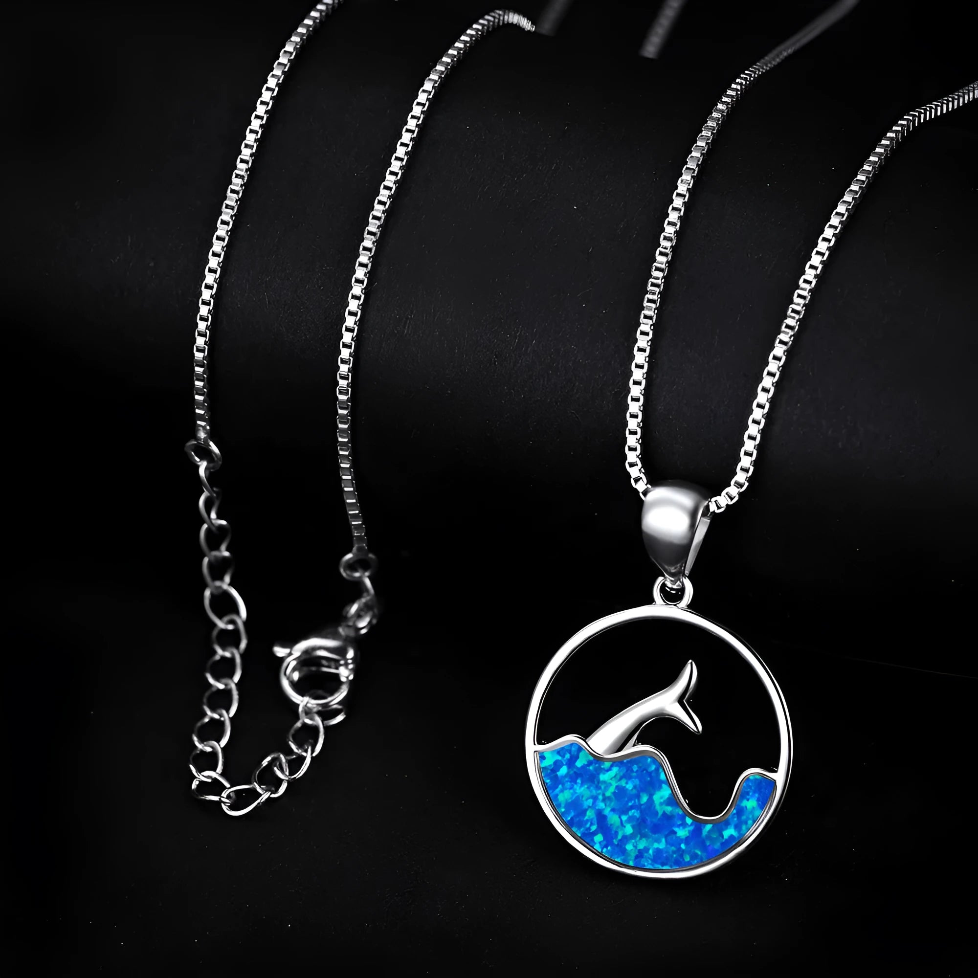 A woman's copper necklace with a round, geometric sea fishtail pendant in a blue opal colour finish.