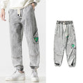 Men's loose-fit tapered cotton trousers shown in black, blue, and grey colour options.