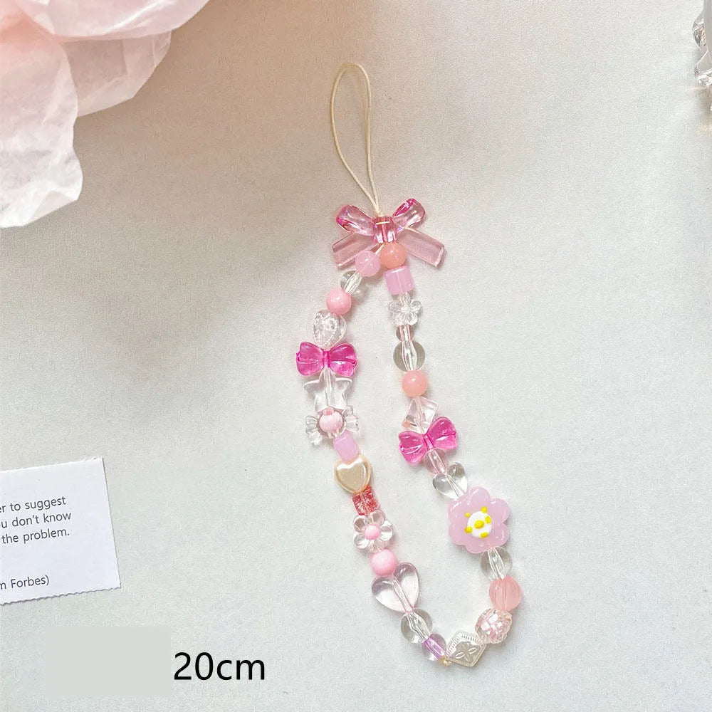 Colourful beaded mobile phone lanyard with a blue resin flower charm on a hand strap.