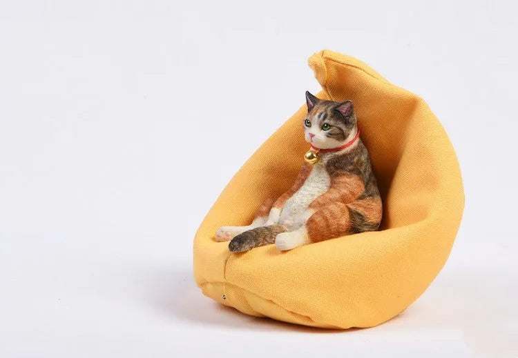 Resin lazy cat car ornament with fabric sofa, approximately 7.5cm high.