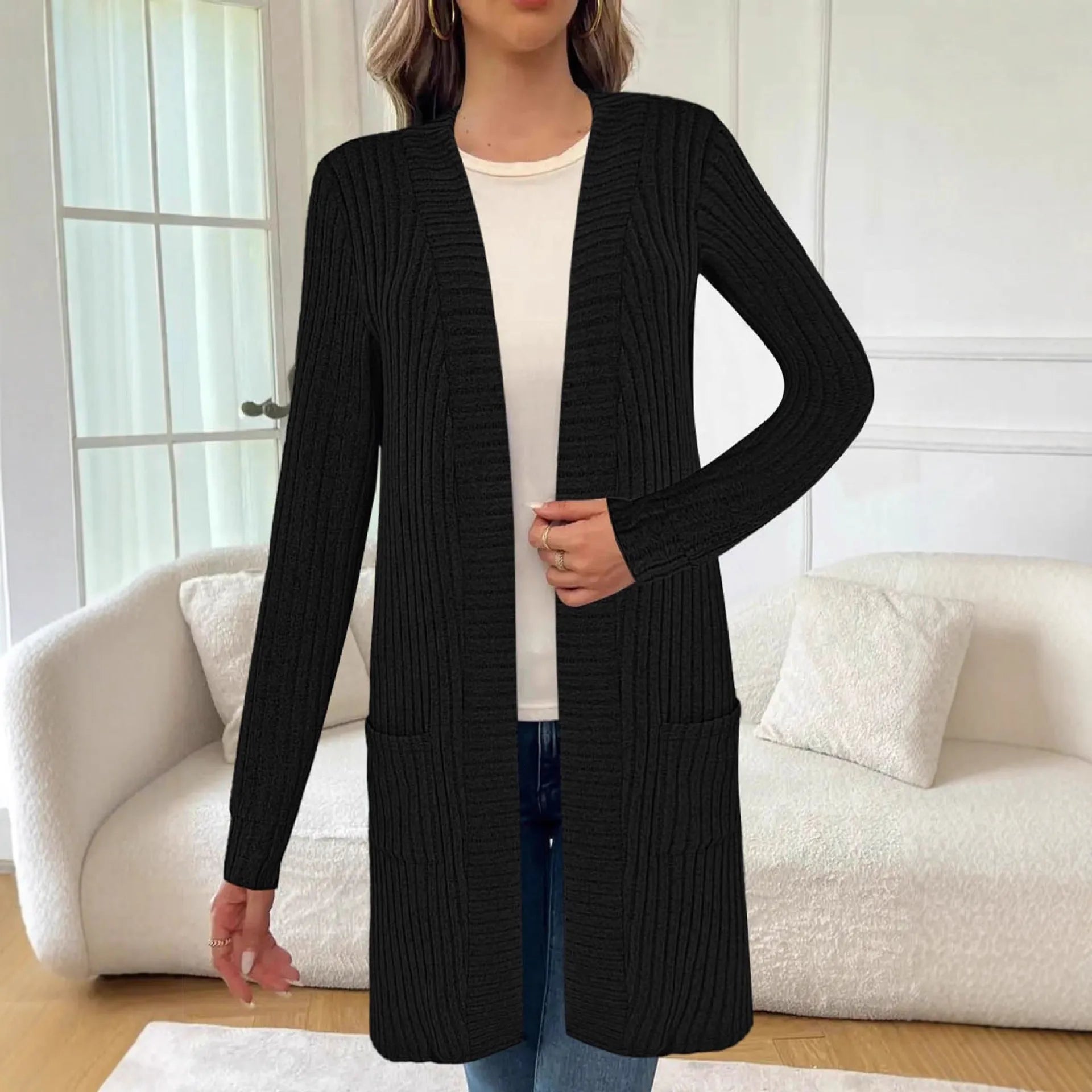 A woman wearing a loose-fit long sleeve knitted cardigan jacket with pockets, available in black, grey, or wine red.