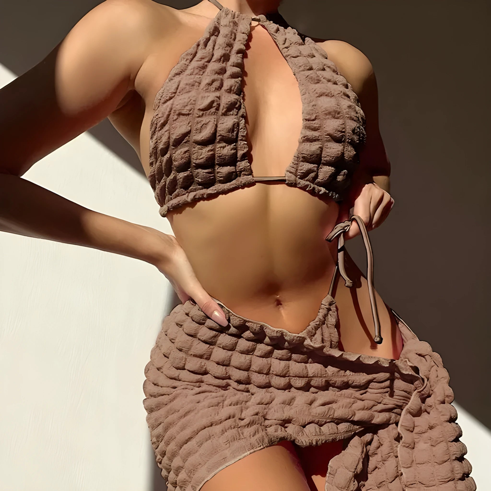 Brown seersucker lace-up three-piece bikini swimsuit for women laid flat, showing top, pants, and skirt.