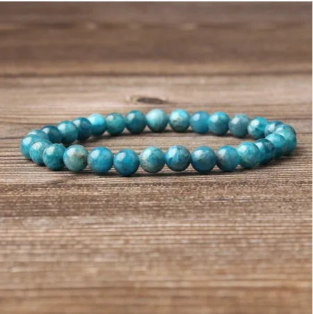 Natural blue apatite elastic beaded bracelet with polished round beads, unisex design, shown on a neutral background