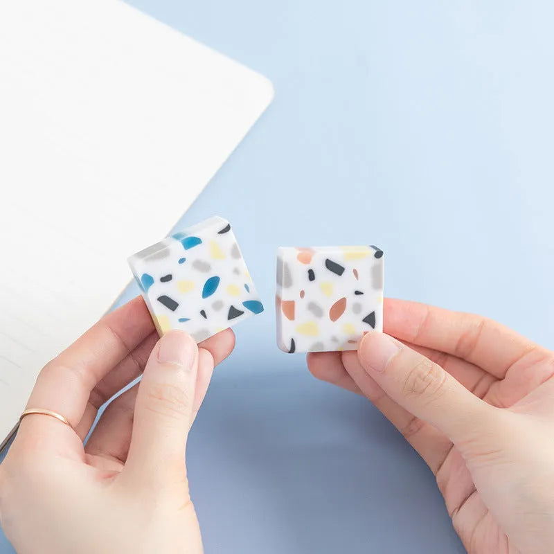 Small white PVC eraser for art drawing on a blue background.