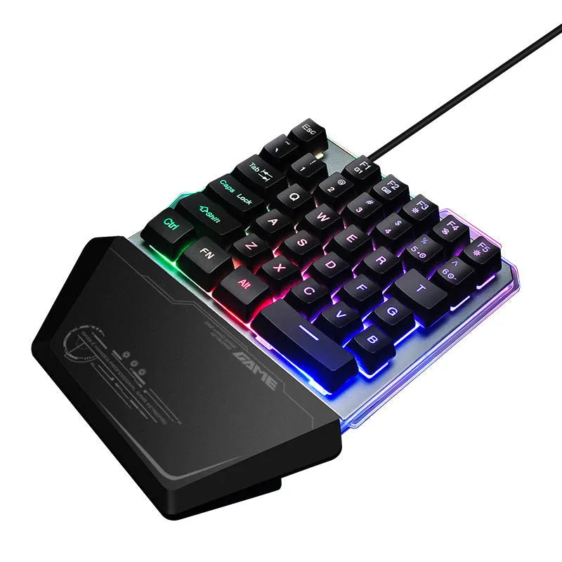 Black robotic one-handed mechanical keyboard with RGB backlit keys on a desk.