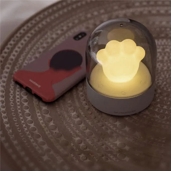 Grey cat paw USB charging music box night light with adjustable brightness on wooden desk