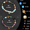 Set of two natural stone beaded bracelets for zodiac signs on a flat surface.