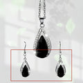 Black and red teardrop glass pendant necklace and matching earrings set on a white background.