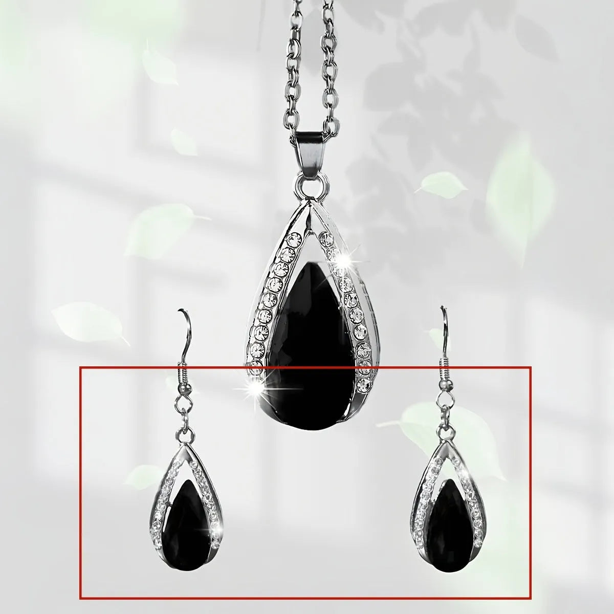Black and red teardrop glass pendant necklace and matching earrings set on a white background.