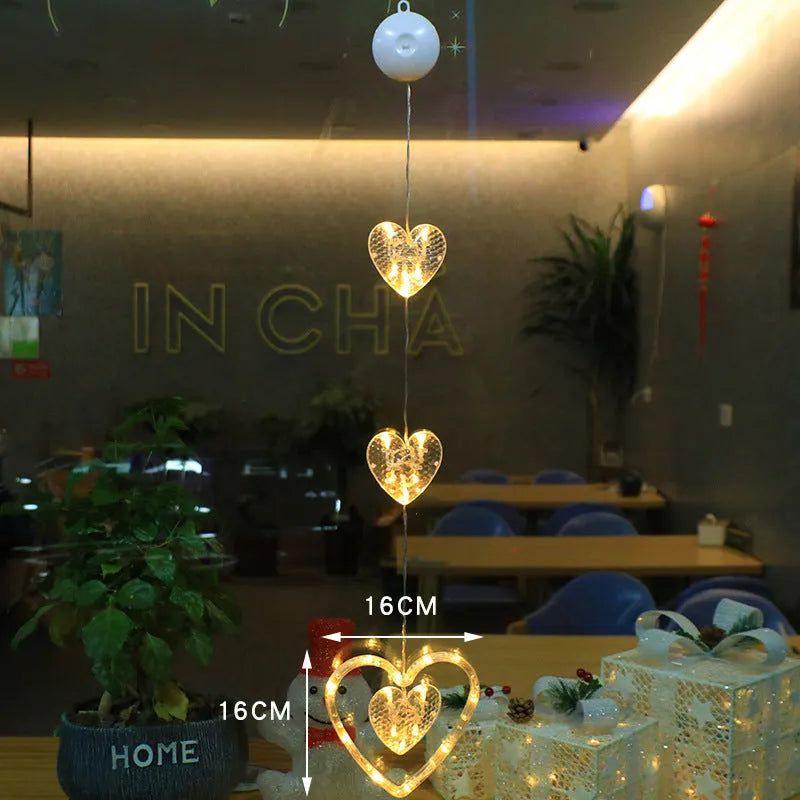 Three Christmas LED light ornaments with suction cups hanging on window