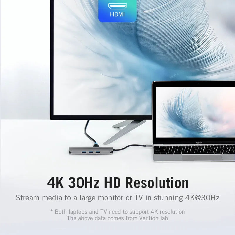Deep grey USB-C to HDMI, USB 3.0, Ethernet, and card reader hub with a short cable on a desk.