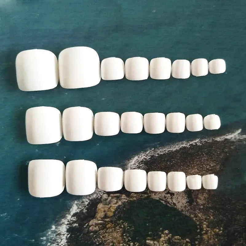 Set of white press-on fake nails with a starry sky pattern, laid out for display.