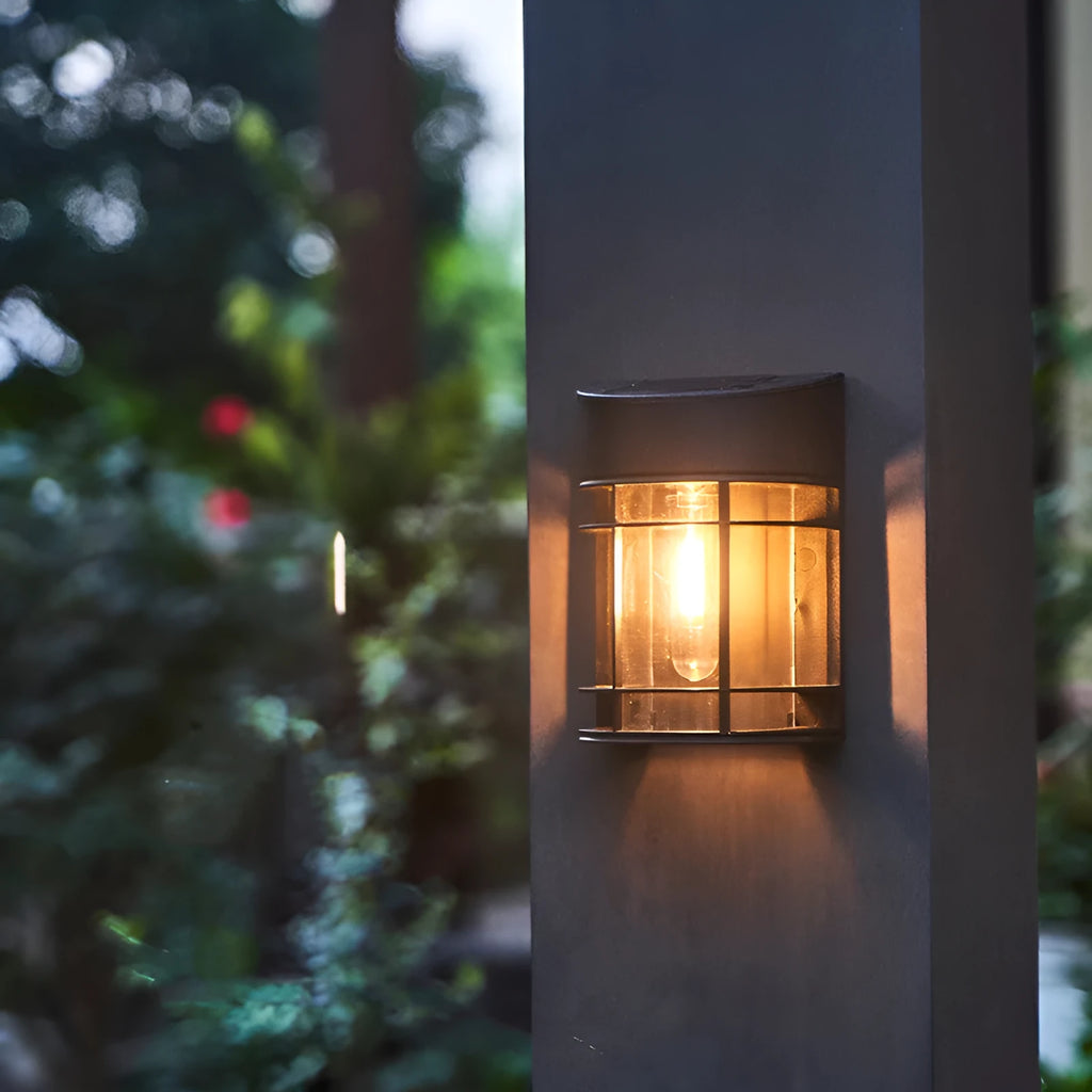 Small white solar-powered outdoor wall light with a dark solar panel on top, mounted on a wall.