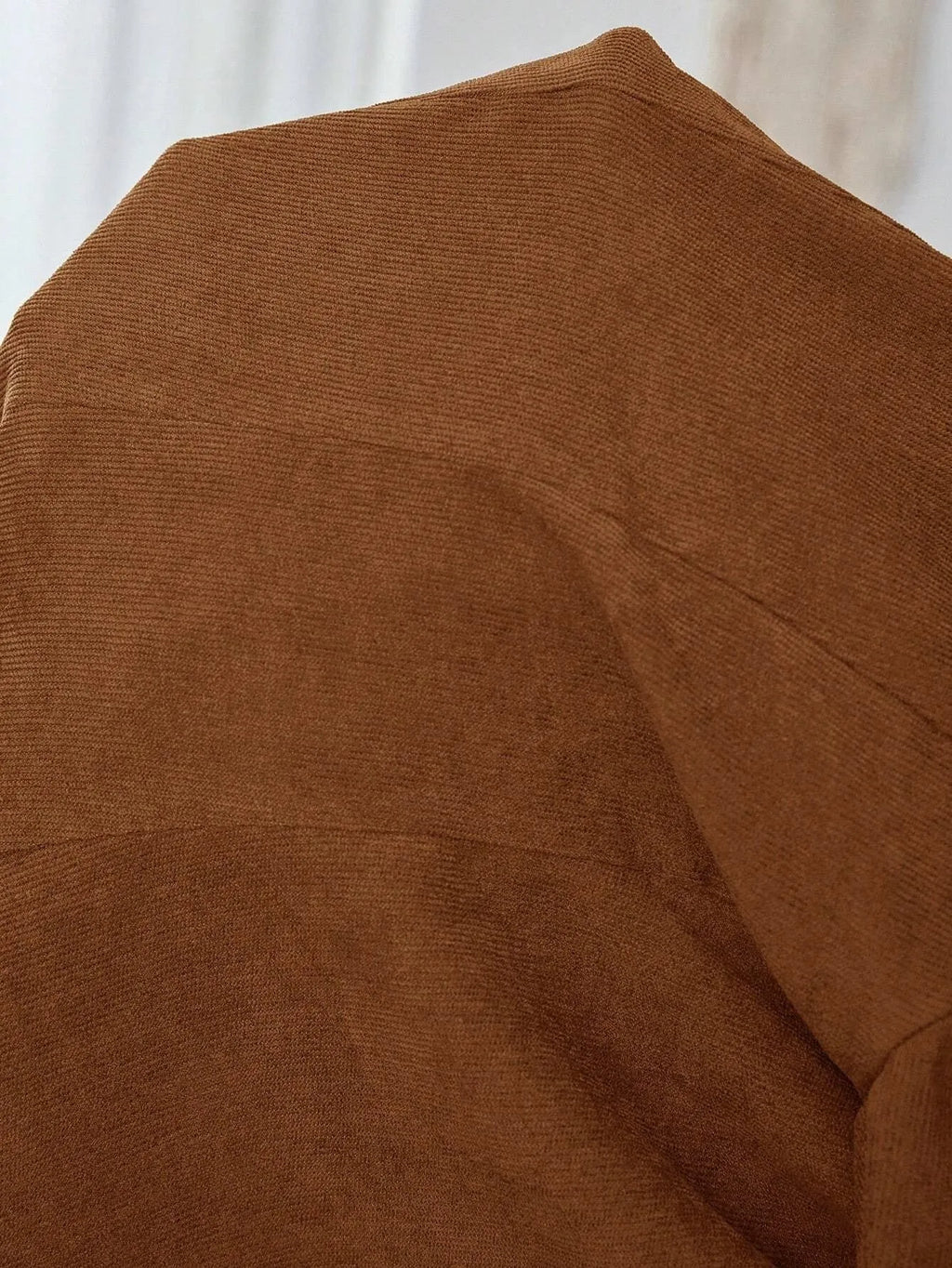 Brown men's single-breasted lapel suit coat on a hanger.
