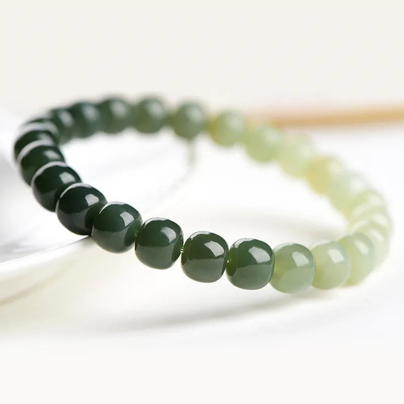 Natural Hetian jade bracelet with gradient clear water colours on a wrist, showing polished beads.