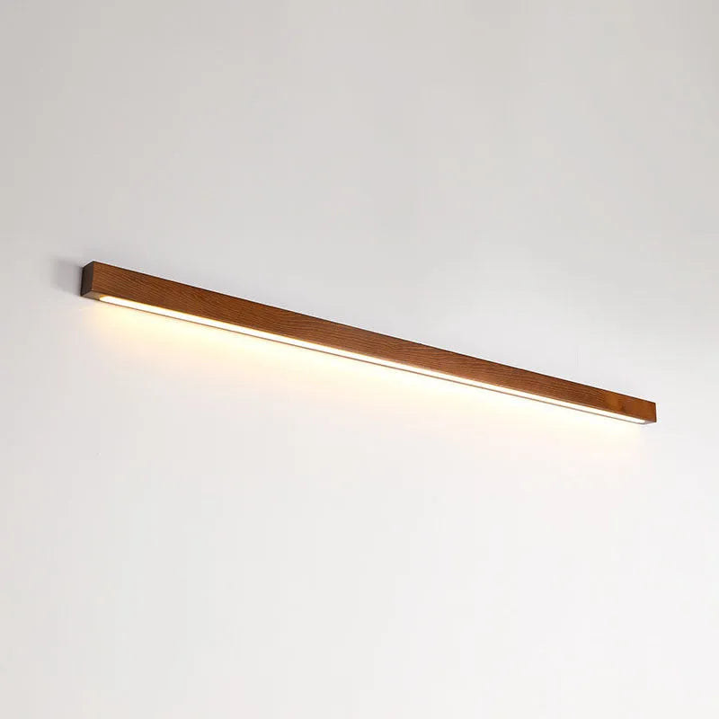 Modern Walnut wood and acrylic log strip wall lamp mounted on a wall in a living room setting.