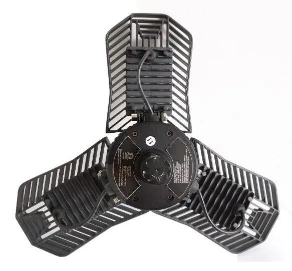 A foldable silver aluminium garage work lamp with a clear plastic lens, shown in an open position.