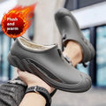 Men's black plastic rain boots on a grey background showing ankle height and solid colour design.