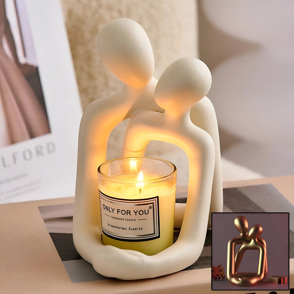 Modern minimalist loving couple resin statue in gold or milky white on a wooden surface.