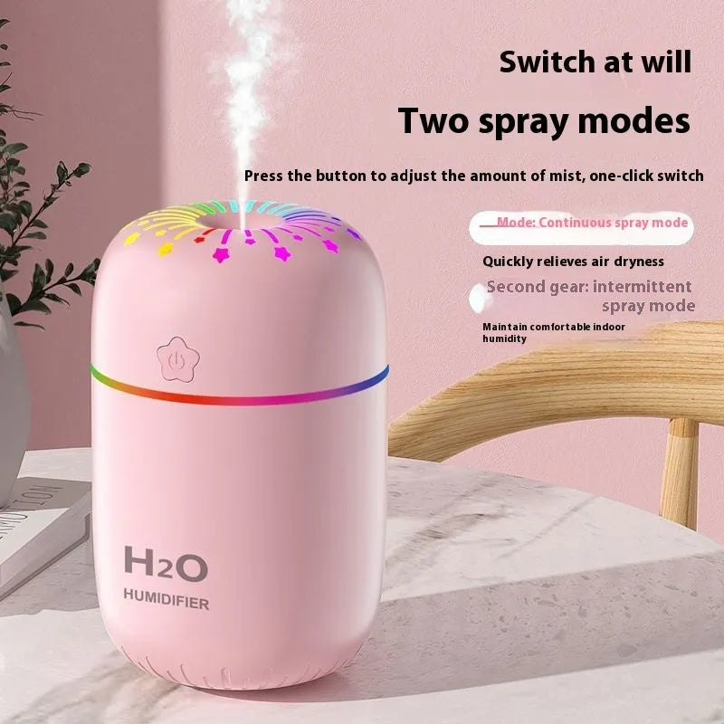 Small white USB portable humidifier with fireworks design on a wooden desk