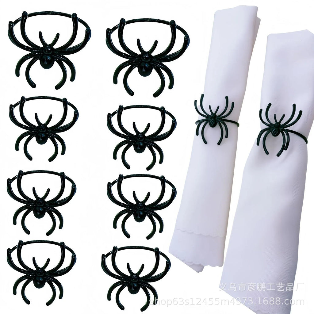 Set of six black metal spider-shaped napkin rings for Halloween table decoration.
