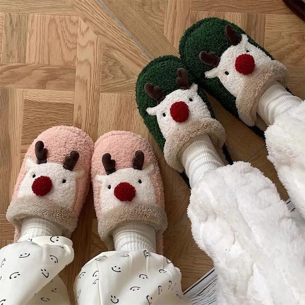 A pair of women's pink cotton slippers with a Christmas deer pattern and a white non-slip PVC sole.