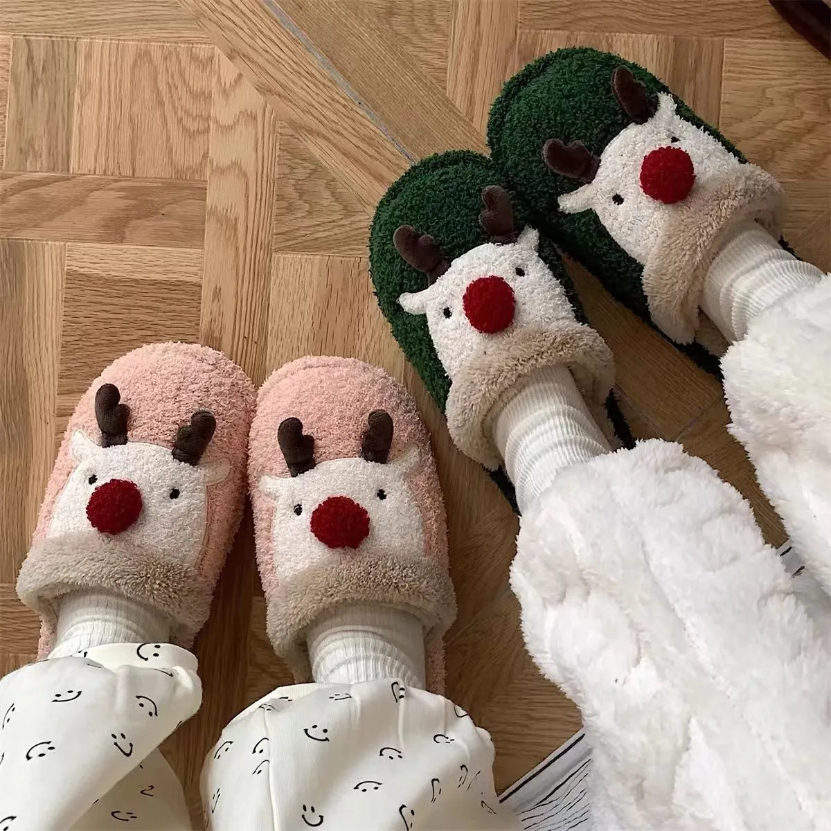 A pair of women's pink cotton slippers with a Christmas deer pattern and a white non-slip PVC sole.
